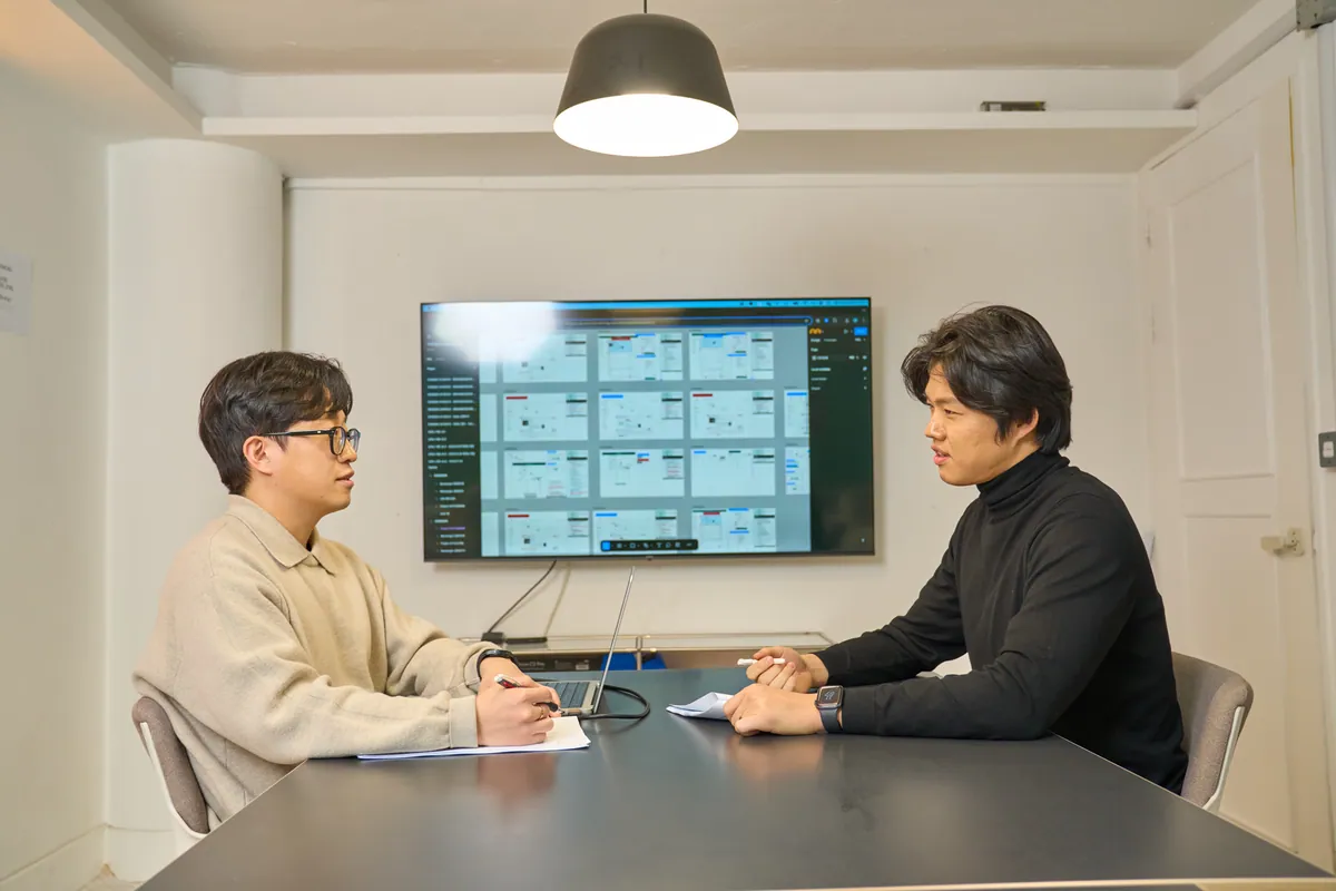 화면 설계 자료를 함께 보며 대화하는 미스터디벨로의 실제 미팅 모습